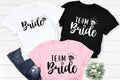 Team Bride t shirt featuring elegant bridal typography with a diamond ring design, perfect for hen parties, bridal showers, wedding mornings and girls' weekends. This personalised bridal party shirt creates stylish matching outfits for bridesmaids and friends while offering premium comfort. Every order is professionally printed in the UK by TeezoraPrints for outstanding print quality.