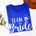 Customise your bridal party with matching Team Bride shirts created for every wedding role. Pair this elegant design with Bride, Bridesmaid, Maid of Honour or other personalised titles to create a coordinated wedding collection. Every shirt is made to order and professionally printed in the UK by TeezoraPrints, delivering premium quality and a truly personal finishing touch.