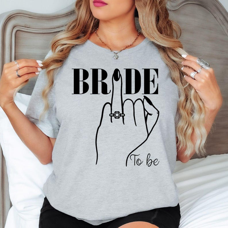This Bride To Be shirt is perfect for bridal showers, engagement parties, hen weekends, bachelorette celebrations, wedding mornings, bridal brunches, engagement photoshoots, rehearsal dinners and honeymoon travel. Designed for comfort and style, every premium shirt is printed in the UK by TeezoraPrints with exceptional attention to detail.