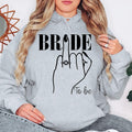 Searching for the perfect engagement gift? This Bride To Be hoodie is a thoughtful keepsake for brides, fiancées and future wives. The elegant bridal illustration makes it an ideal present for bridal showers, engagement celebrations and wedding countdowns. Every personalised hoodie is professionally printed in the UK by TeezoraPrints with exceptional attention to detail.