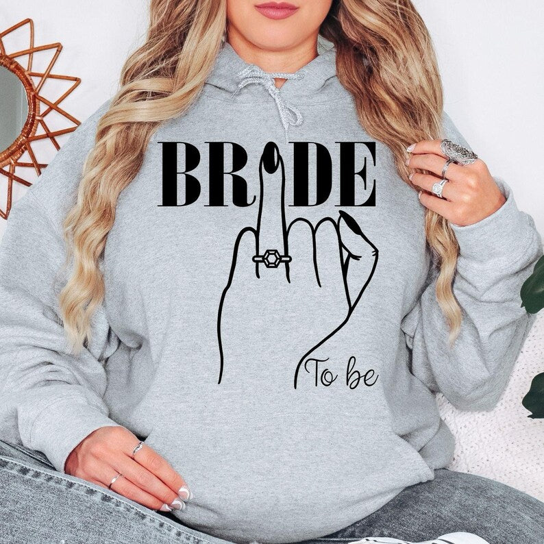 Searching for the perfect engagement gift? This Bride To Be hoodie is a thoughtful keepsake for brides, fiancées and future wives. The elegant bridal illustration makes it an ideal present for bridal showers, engagement celebrations and wedding countdowns. Every personalised hoodie is professionally printed in the UK by TeezoraPrints with exceptional attention to detail.