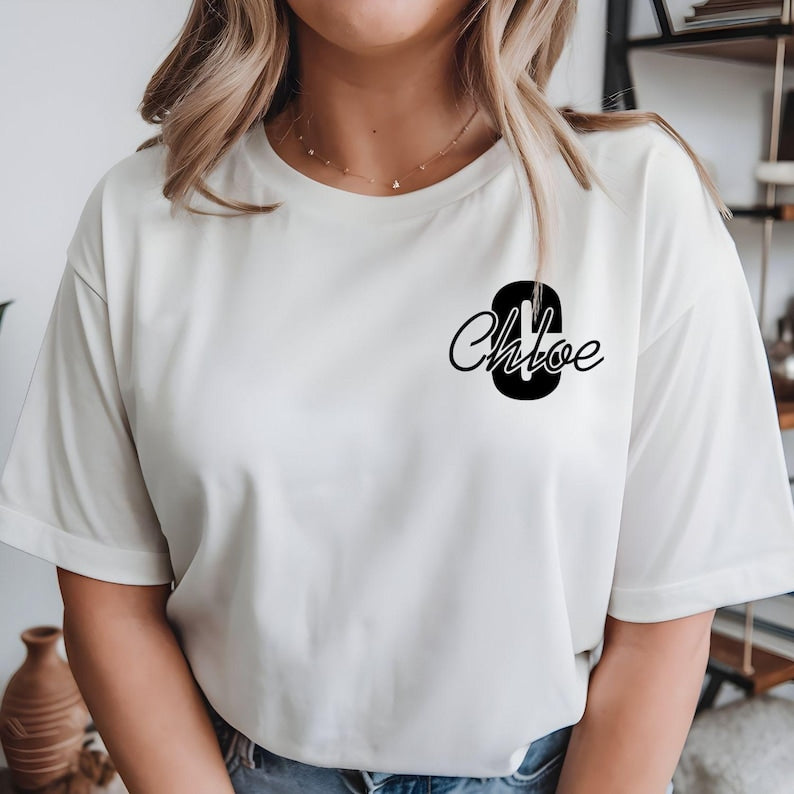 Personalised initial name t shirt featuring a bold monogram letter combined with an elegant script name printed on the left chest area. This custom name tee offers a clean and stylish appearance, making it ideal for personalised fashion lovers seeking unique custom clothing. Professionally printed in the UK using premium quality printing for long-lasting durability and everyday comfort.