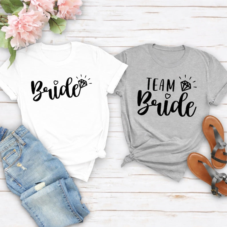 Celebrate every wedding moment with this elegant Team Bride shirt designed to bring your bridal party together. The modern script design with a sparkling diamond icon creates a timeless look that's perfect for matching photos and unforgettable memories. Every premium t-shirt is made to order and printed in the UK by TeezoraPrints with exceptional attention to detail.