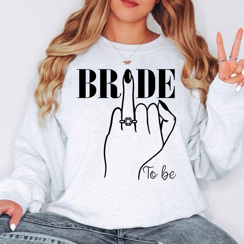 Perfect for bridal showers, engagement celebrations, hen parties, wedding mornings, bridal brunches, rehearsal dinners, honeymoon travel, wedding planning days and engagement photoshoots. This Bride To Be sweatshirt combines warmth, elegance and premium craftsmanship, with every order professionally printed in the UK by TeezoraPrints for a beautiful finishing touch.