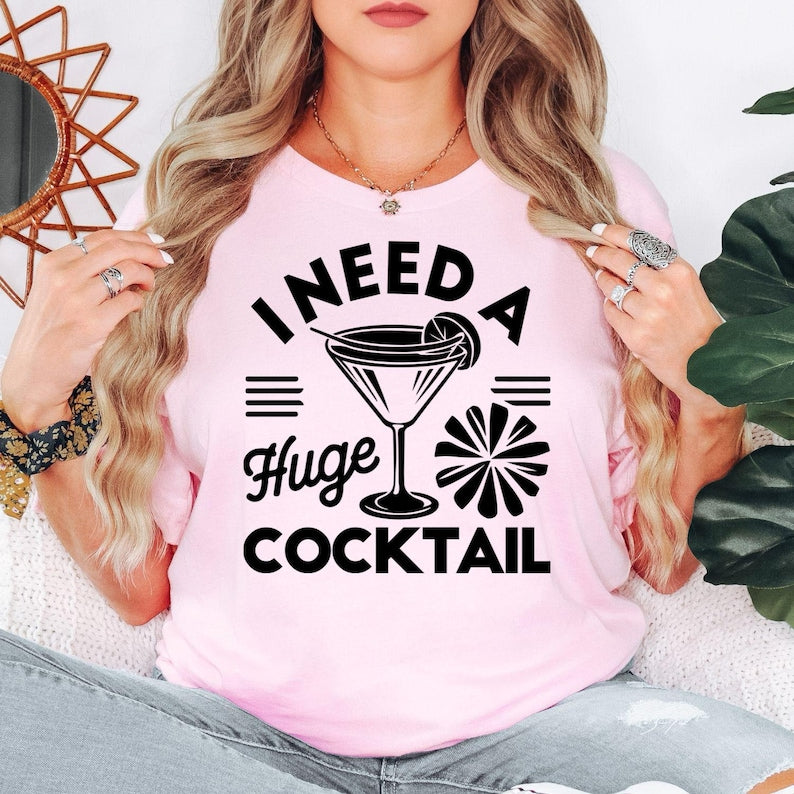Funny cocktail t shirt designed for women who love cocktails, girls' nights out, brunch dates, weekend parties, and fun social events. Featuring the bold "I Need A Huge Cocktail" quote with a stylish cocktail glass graphic, this novelty tee is perfect for friends, sisters, wives, girlfriends, and cocktail enthusiasts who enjoy expressing their personality through humorous fashion. A comfortable statement shirt ideal for celebrations, holidays, and everyday casual wear.
