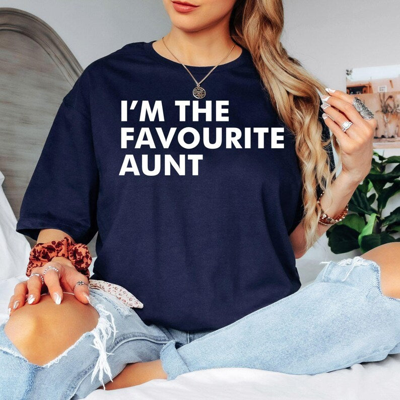 I'm The Favourite Aunt T Shirt featuring a bold typography family quote designed for proud aunties, sisters, and family humour lovers. Teezora Prints creates premium apparel for customers searching funny aunt shirts, cool aunt clothing, favourite aunt gifts, auntie graphic tees, family humour apparel, typography fashion, premium casual t shirts, unique aunt gifts, and stylish everyday clothing for women who love their family.