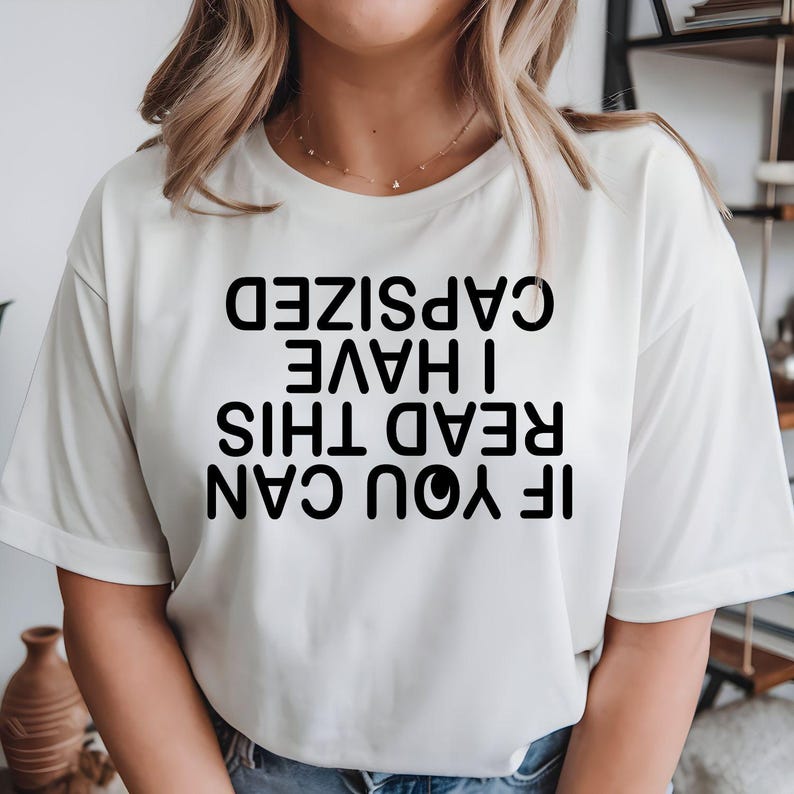 If You Can Read This I Have Capsized t shirt designed for passionate kayakers, canoe enthusiasts, paddle boarders, whitewater adventurers, outdoor explorers, campers, boaters, and water sports lovers who enjoy adding humour to every adventure. Featuring a bold upside-down typography design with a hilarious kayaking joke, this premium graphic tee is perfect for lake weekends, river expeditions, kayaking clubs, camping holidays, family adventures, and anyone who believes every capsize becomes the best story t
