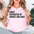 Easily Distracted By Horses And Dogs t shirt is perfect for horse riding lessons, equestrian competitions, dog walks, pet shows, farm visits, stable work, countryside holidays, outdoor adventures, family gatherings, birthdays, weekend outings, animal rescue events, horse club meetings, casual everyday wear, and community festivals. The bold typography design creates a fun conversation starter while proudly celebrating a love for horses, dogs, animals, and the outdoor lifestyle.