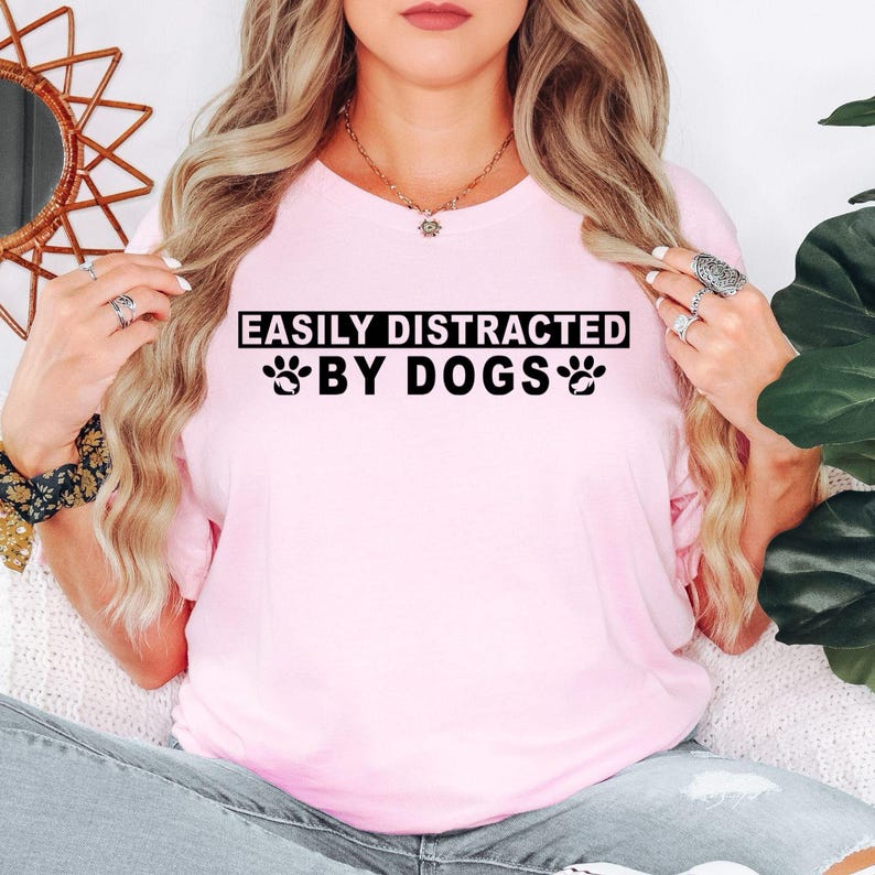 Easily Distracted By Dogs t shirt makes a thoughtful gift for dog mums, dog dads, puppy parents, rescue volunteers, veterinarians, dog groomers, pet sitters, trainers, animal lovers, family members, friends, and anyone who cannot walk past a dog without stopping to say hello. This premium graphic shirt is perfect for birthdays, Christmas, Mother's Day, Father's Day, pet adoption anniversaries, thank you gifts, and special surprises for every dog enthusiast.