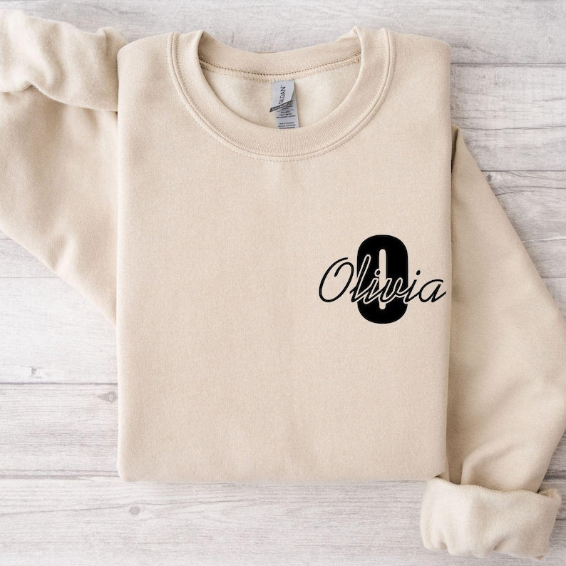 Stylish personalised initial sweatshirt with elegant script typography, perfect for casual outfits, cosy winter fashion, autumn layering, weekend wear, coffee dates, shopping trips, travelling, relaxing at home, and everyday personalised clothing collections.