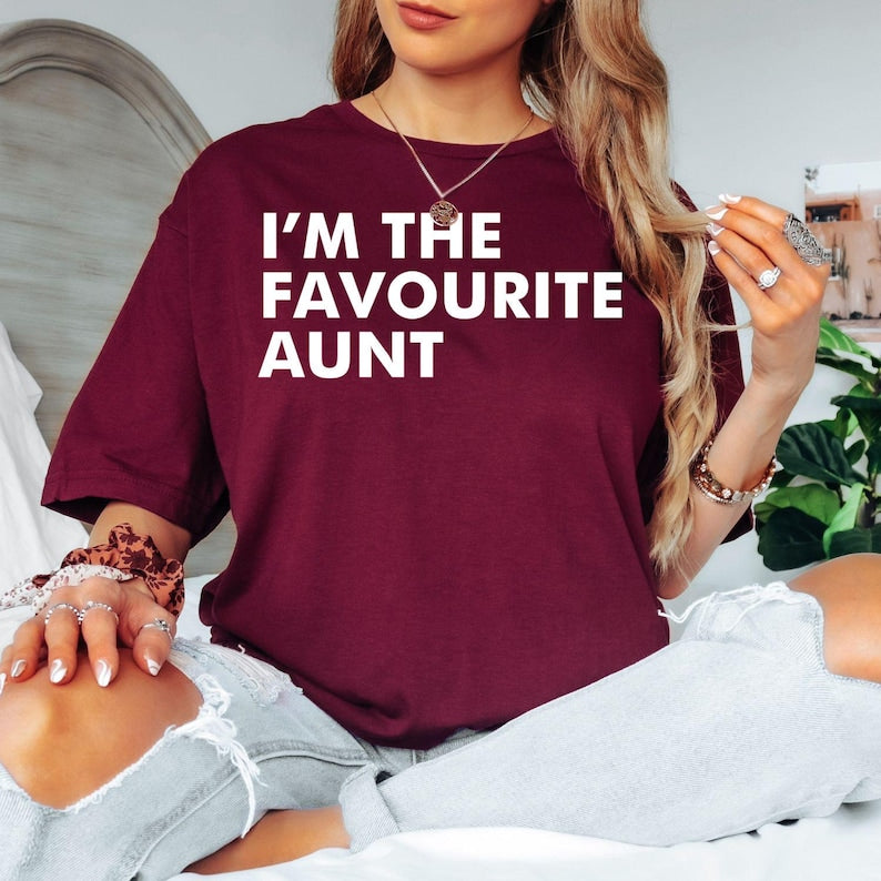 I'm The Favourite Aunt T Shirt created for proud aunts, cool aunties, family members, sisters, godmothers, best friends, and women who love celebrating the special bond with their nieces and nephews. Featuring bold minimalist typography, this premium graphic tee from Teezora Prints combines comfort, premium print quality, and stylish everyday fashion while making a fun family statement that's perfect for every favourite aunt.