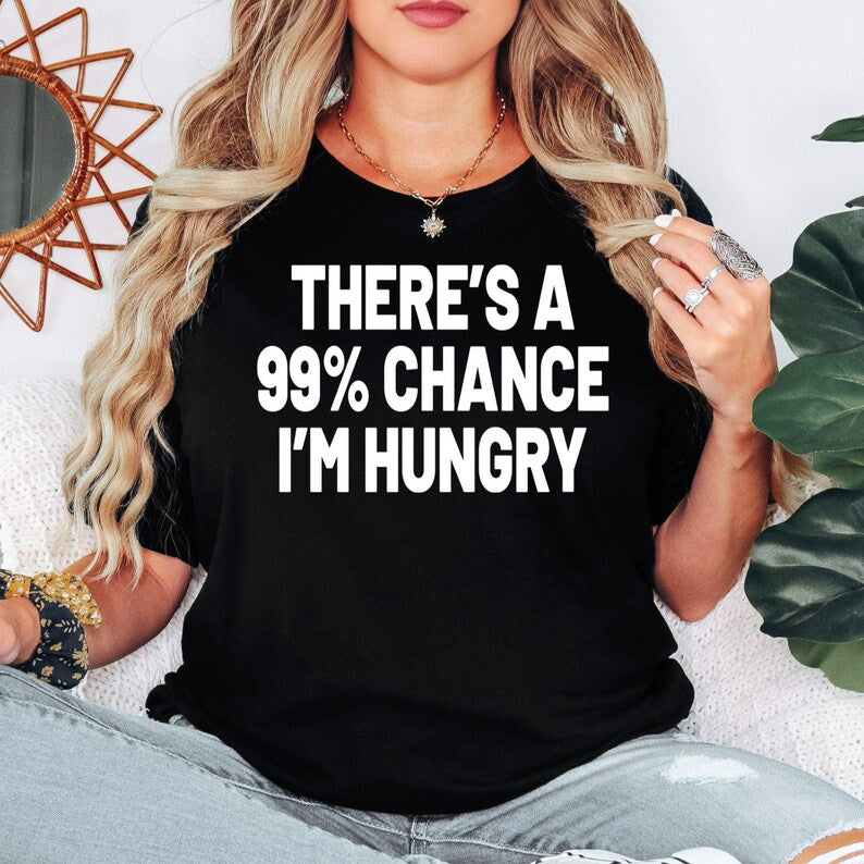 There's A 99% Chance I'm Hungry t shirt created for food lovers, foodies, snack enthusiasts, burger fans, pizza lovers, takeaway addicts, coffee drinkers, dessert lovers, students, parents, chefs, and anyone who jokes that they are always hungry. This premium graphic tee features bold typography with a humorous statement that perfectly matches everyday foodie life while providing exceptional comfort, premium print quality, and stylish casual fashion for every occasion.