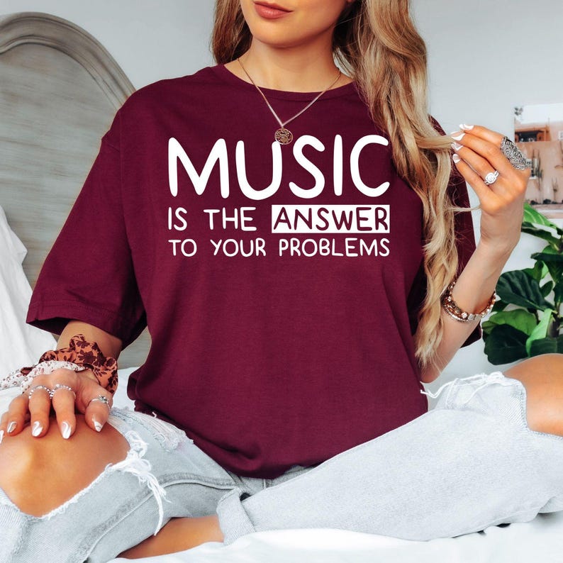 Searching for the perfect gift for someone who lives and breathes music? This Music Is The Answer To Your Problems t shirt features a bold typography design with a positive message that every music lover can relate to. Professionally printed on a premium quality unisex t shirt, it provides exceptional comfort, long-lasting durability, and timeless style. Perfect for birthdays, Christmas, music festivals, concerts, rehearsals, music lessons, and thoughtful gifts for musicians, singers, DJs, teachers, and mus