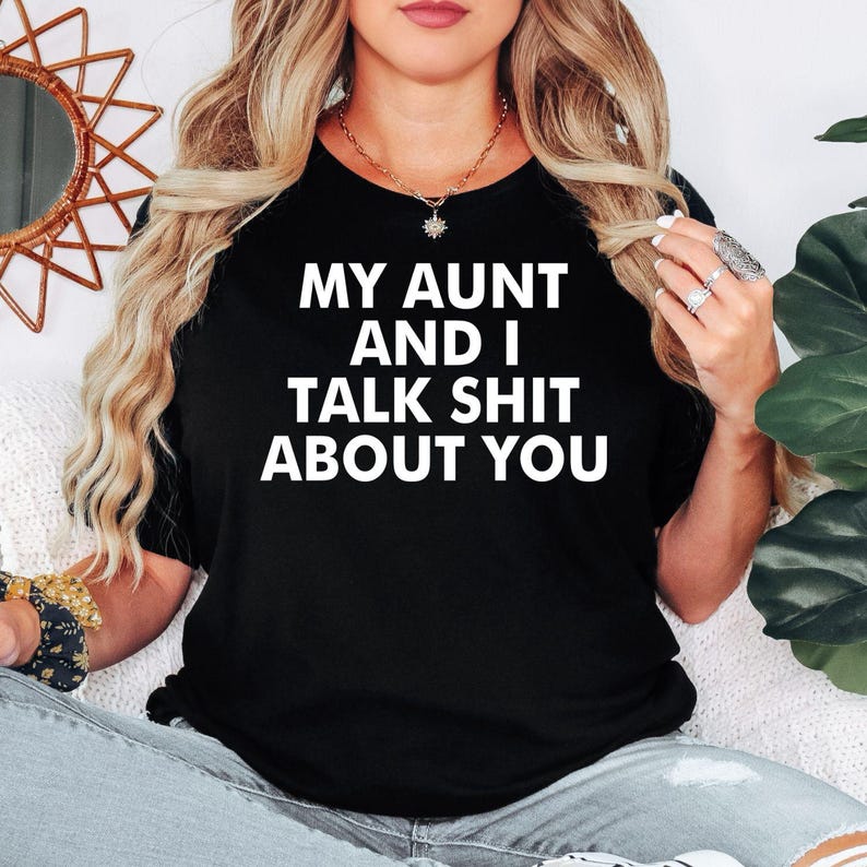 My Aunt And I Talk Shit About You t shirt created for aunts, nieces, nephews, sisters, cousins, best friends, and anyone who loves sarcastic family humour with a bold personality. Featuring an eye-catching typography design, this premium graphic tee celebrates close family relationships, inside jokes, confidence, and unforgettable laughter. Perfect for casual everyday wear, family gatherings, girls' weekends, holidays, birthdays, reunions, and anyone who enjoys playful humour with the people they love most.