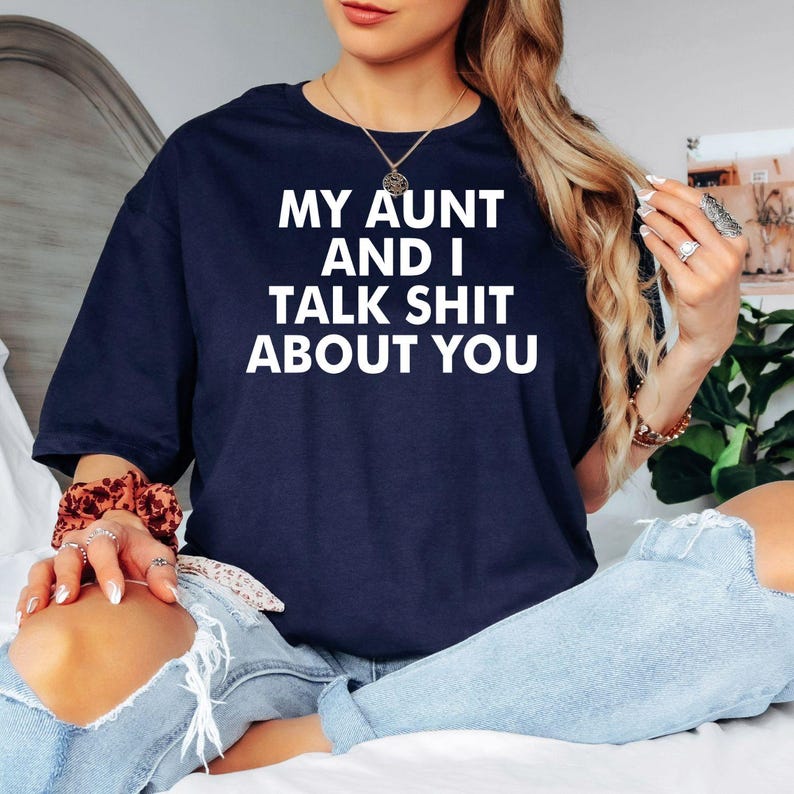 Funny aunt t shirt featuring the quote My Aunt And I Talk Shit About You in a bold typography design created for people who love sarcastic family humour. Perfect for customers searching aunt shirts, funny family quote tees, novelty graphic apparel, witty statement clothing, aunt birthday gifts, family reunion outfits, humorous typography shirts, premium graphic fashion, and unique conversation starter t shirts for adults.