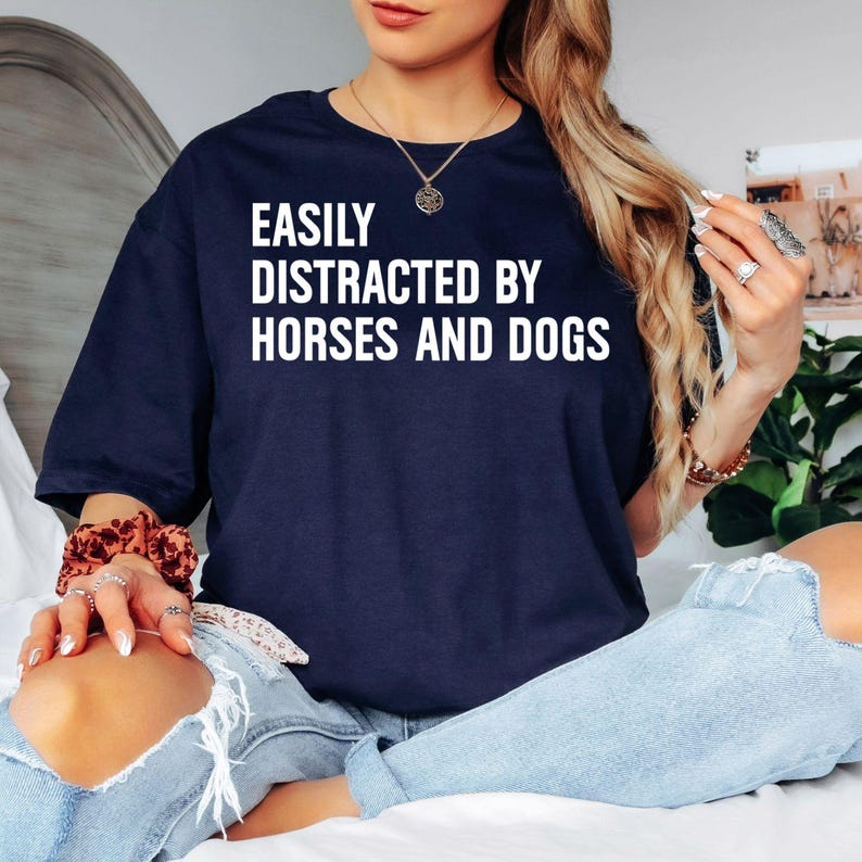 Looking for the perfect gift for someone who loves both horses and dogs? This Easily Distracted By Horses And Dogs t shirt features a bold typography design that instantly captures the personality of every true animal lover. Professionally printed on a premium quality unisex t shirt, it delivers outstanding comfort, durability, and timeless style. Perfect for birthdays, Christmas, Mother's Day, Father's Day, horse riding events, dog walks, farm visits, equestrian competitions, and thoughtful gifts for pet l