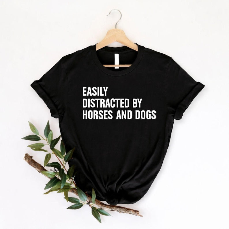 Easily Distracted By Horses And Dogs t shirt created for horse lovers, dog lovers, equestrians, riders, pet parents, animal rescuers, stable owners, trainers, veterinarians, farm life enthusiasts, and anyone whose day instantly gets better after seeing a horse or a dog. Featuring a bold typography design with a playful statement, this premium graphic tee perfectly reflects an animal lover's personality while offering exceptional comfort, durable print quality, stylish everyday fashion, and a fun conversatio