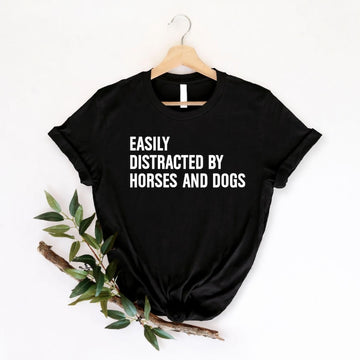 Easily Distracted By Horses And Dogs t shirt created for horse lovers, dog lovers, equestrians, riders, pet parents, animal rescuers, stable owners, trainers, veterinarians, farm life enthusiasts, and anyone whose day instantly gets better after seeing a horse or a dog. Featuring a bold typography design with a playful statement, this premium graphic tee perfectly reflects an animal lover's personality while offering exceptional comfort, durable print quality, stylish everyday fashion, and a fun conversatio
