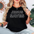 Jesus Saves T Shirt featuring a bold Christian faith message, minimalist typography design, religious graphic apparel, Bible-inspired clothing, worship shirt, church fashion, Gospel statement tee, premium printed Christian clothing, casual faith apparel, and inspirational everyday wear. Perfect for customers searching Christian t shirts, Jesus shirts, faith clothing, church apparel, Bible verse shirts, worship clothing, Christian gifts, religious graphic tees, and premium Christian fashion.