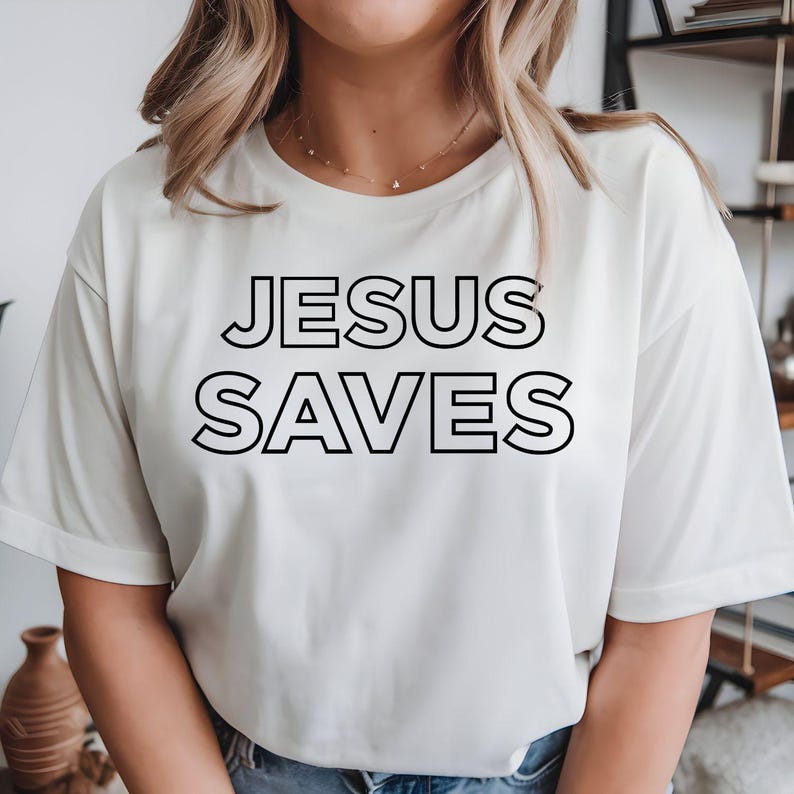 Jesus Saves t shirt created for Christians, believers, church members, pastors, youth groups, worship leaders, missionaries, Bible study members, faith-filled families, and anyone who proudly shares the Gospel. Featuring a bold minimalist typography design, this premium Christian graphic tee is perfect for expressing faith with confidence while offering exceptional comfort, professional print quality, timeless style, and meaningful everyday Christian clothing that inspires conversations about Jesus Christ a
