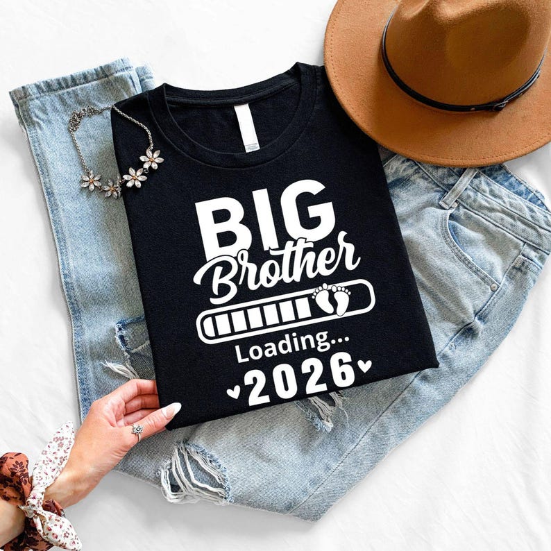 Personalised Big Brother Loading T Shirt featuring a custom year design, loading progress bar graphic and baby footprints. This premium printed sibling announcement shirt is designed to celebrate the exciting journey of becoming a big brother. Perfect for pregnancy announcements, family reveals and memorable family milestones. Professionally printed in the UK using high quality DTF printing for durability, comfort and long-lasting wear.