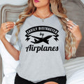 Easily Distracted By Airplanes T Shirt designed for people who live and breathe aviation, travel, and adventure. Whether you're a pilot, plane spotter, cabin crew member, aircraft engineer, aviation student, or someone who always looks up when a plane flies overhead, this premium graphic tee perfectly reflects your passion. Featuring a bold airplane silhouette with stylish typography, it's ideal for airport visits, travel days, airshows, flying clubs, vacations, aviation photography, and everyday casual wea