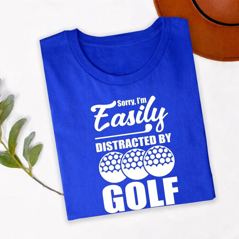 Teezora Prints Sorry I'm Easily Distracted By Golf T Shirt is perfect for golf tournaments, golf club events, driving range practice, weekend golf trips, holidays, sports events, birthdays, retirement parties, Father's Day celebrations, casual everyday wear, golf vacations, family outings, clubhouse gatherings, and outdoor adventures. The bold typography and golf ball design create a fun conversation starter while celebrating a lifelong passion for golf and the golfing lifestyle.