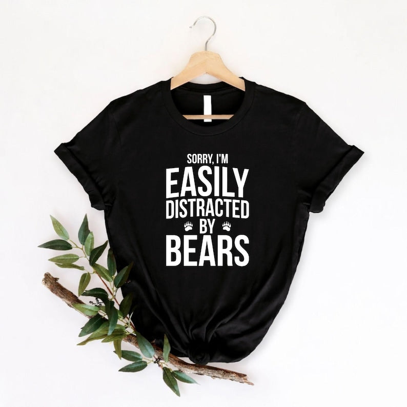 Teezora Prints Sorry I'm Easily Distracted By Bears T Shirt created for bear lovers, wildlife enthusiasts, hikers, campers, nature lovers, outdoor adventurers, national park visitors, forest explorers, animal lovers, and anyone fascinated by bears. Featuring bold typography with paw print accents, this premium graphic tee celebrates a love for wildlife while providing exceptional comfort, professional print quality, stylish everyday fashion, and a fun personality for every outdoor enthusiast.
