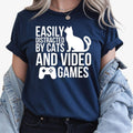 Funny Gamer Shirt, Easily Distracted By Cats And Video Games Shirt, Cat Lover T Shirt, Gaming Shirt, Video Game Tee, Cat Graphic Shirt, Gamer Gift, Gaming Controller Tee, PC Gamer Shirt, Console Gamer Tee, Cat Mum Shirt, Cat Dad Shirt, Funny Cat Shirt, Gaming Apparel, Animal Lover Tee, Premium Graphic T Shirt by Teezora Prints, Gamer Clothing, Cat Lover Gift, Gaming Fashion, Casual Gamer Tee, Video Game Lover Shirt, Esports Shirt, Cat Owner Apparel, Gamer Lifestyle Shirt.