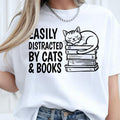 Funny Cat Shirt, Easily Distracted By Cats And Books Shirt, Book Lover T Shirt, Cat Lover Tee, Bookworm Shirt, Reading Shirt, Librarian Shirt, Teacher Tee, Sleeping Cat Shirt, Book Stack Shirt, Reader Gift, Cat Mum Shirt, Cat Dad Shirt, Animal Lover Tee, Literary Shirt, Premium Graphic T Shirt by Teezora Prints, Reading Apparel, Novel Lover Shirt, Library Shirt, Casual Book Lover Clothing, Bookish Tee, Reading Graphic Shirt, Cat Gift, Book Gift.