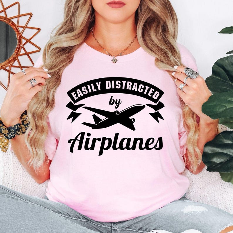 Easily Distracted By Airplanes t shirt is perfect for airshows, airport visits, aviation museums, flying lessons, pilot training, travel holidays, aircraft exhibitions, aviation club meetings, family vacations, birthdays, casual everyday wear, photography trips, aviation festivals, weekend adventures, flight simulator events, and social gatherings. The bold airplane silhouette and modern typography create a striking conversation starter while celebrating a lifelong passion for aviation and flight.