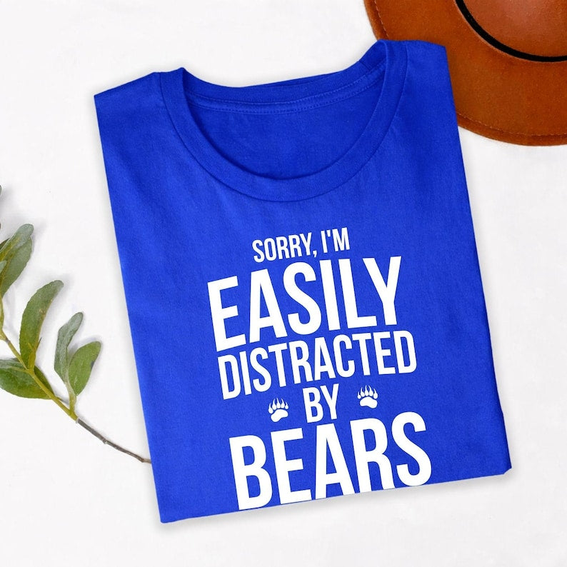 Teezora Prints Sorry I'm Easily Distracted By Bears T Shirt is perfect for camping weekends, hiking trails, national park visits, wildlife tours, mountain holidays, outdoor festivals, family adventures, birthdays, vacations, forest walks, road trips, casual everyday wear, camping clubs, nature photography trips, and outdoor gatherings. The bold typography and paw print design create a fun conversation starter while celebrating a passion for bears, wildlife, and the great outdoors.