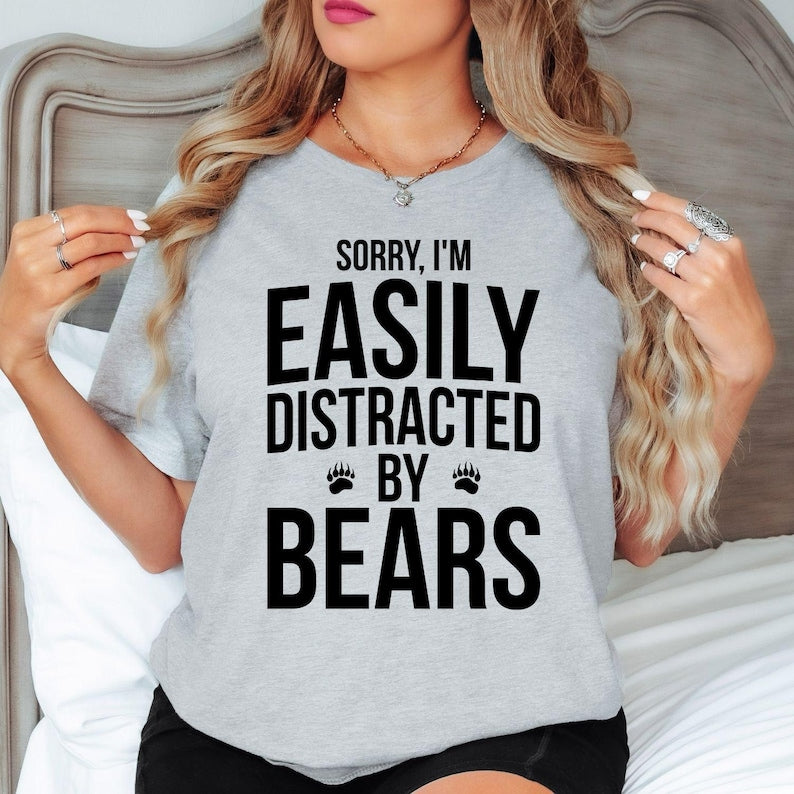 Teezora Prints Sorry I'm Easily Distracted By Bears T Shirt designed for people who feel happiest exploring forests, mountains, hiking trails, and national parks where wildlife thrives. Featuring a bold typography design with paw print graphics, this premium graphic tee is perfect for campers, adventurers, outdoor lovers, and anyone proud to show their love for bears. Ideal for travel, camping holidays, hiking adventures, weekend escapes, wildlife photography,stylish everyday casual wear inspired nature.