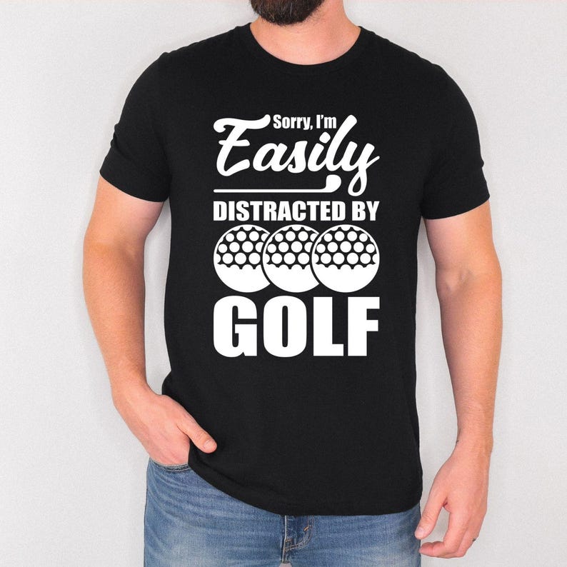 Teezora Prints Sorry I'm Easily Distracted By Golf T Shirt created for golfers, golf enthusiasts, weekend players, golf club members, PGA fans, golf coaches, retirees, dads, mums, and anyone whose favourite place is the golf course. Featuring bold typography with realistic golf balls, this premium graphic tee reflects the passion every golfer feels while delivering exceptional comfort, durable print quality, stylish everyday fashion, and a fun personality that instantly connects with fellow golf lovers on a