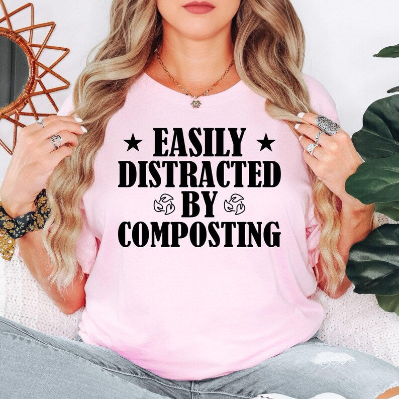 Celebrate your passion for gardening and sustainable living with this Easily Distracted by Composting shirt. Designed for people who enjoy growing plants, recycling naturally and spending time outdoors, this premium graphic tee offers everyday comfort and timeless style. Every shirt is proudly printed in the UK by TeezoraPrints with attention to every detail.