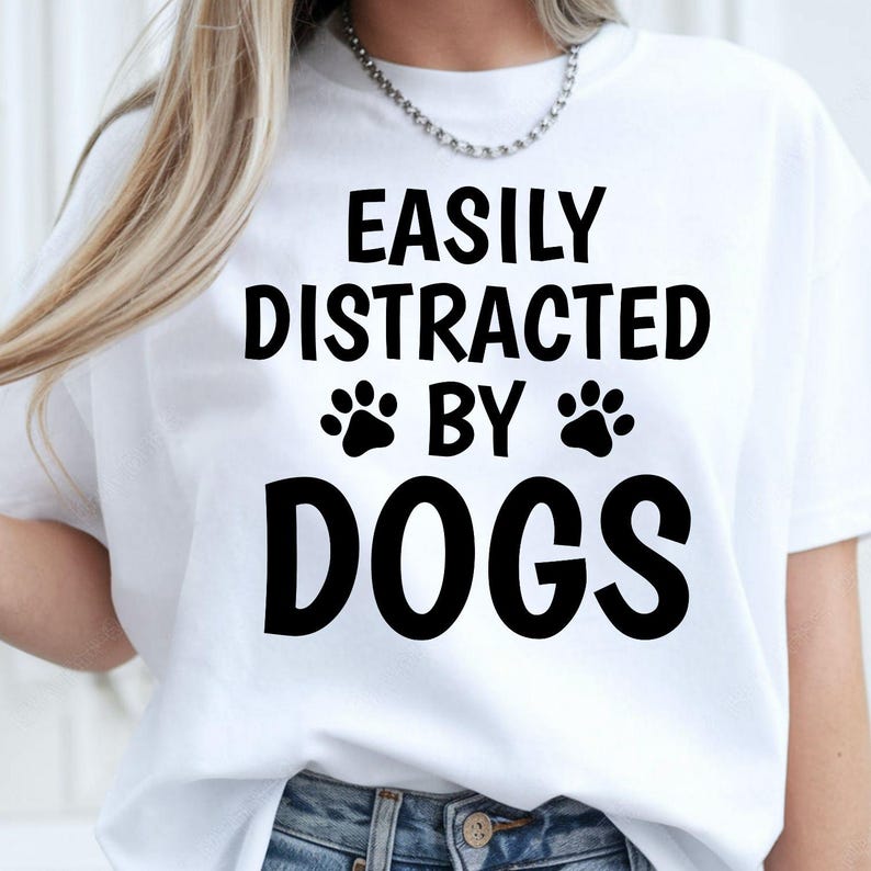 Easily Distracted by Dogs shirt, funny dog lover t shirt, pet lover tee, dog mum shirt, dog dad shirt, puppy lover apparel, paw print shirt, canine lover clothing, novelty dog t shirt, animal lover gift and casual everyday fashion. Every premium tee is carefully printed in the UK by TeezoraPrints for comfort, durability and exceptional print quality.