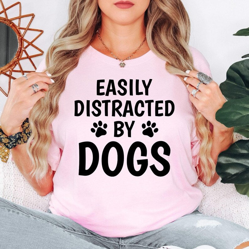 Searching for the perfect gift for someone who loves dogs? This Easily Distracted by Dogs shirt is an ideal present for birthdays, Christmas, Mother's Day, Father's Day or any special occasion. Featuring a bold paw print design and humorous slogan, every shirt is professionally printed in the UK by TeezoraPrints for premium quality.