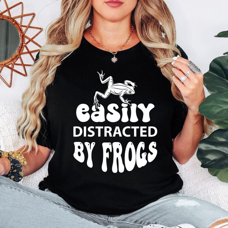 Perfect for frog lovers, amphibian enthusiasts, wildlife fans and nature explorers, this Easily Distracted by Frogs shirt features a bold frog illustration with retro-inspired typography for a fun everyday look. Whether you're exploring forests, visiting ponds or enjoying outdoor adventures, this premium t-shirt offers exceptional comfort. Professionally printed in the UK by TeezoraPrints using premium-quality materials.