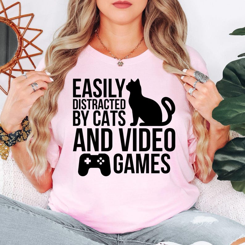 Easily Distracted By Cats And Video Games T Shirt is perfect for gaming nights, LAN parties, esports tournaments, comic conventions, casual weekends, streaming sessions, birthdays, holidays, gaming cafés, family gatherings, college life, everyday casual wear, and relaxing at home with your favourite cat. Teezora Prints combines premium quality with fun gaming style to create a shirt every gamer will enjoy wearing.