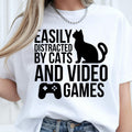 Easily Distracted By Cats And Video Games T Shirt created for cat lovers, gamers, streamers, console players, PC gamers, pet parents, esports fans, and anyone whose two greatest passions are cats and gaming. Featuring a playful cat silhouette with a game controller, this premium graphic tee from Teezora Prints delivers exceptional comfort, professional print quality, stylish everyday fashion, and the perfect conversation starter for gaming and feline enthusiasts alike.