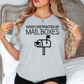 Celebrate your love for postal life with this Easily Distracted by Mailboxes shirt featuring a bold mailbox graphic and playful slogan. Whether delivering letters, collecting mail or enjoying casual weekends, this premium t-shirt offers comfort and timeless style. Every shirt is proudly printed in the UK by TeezoraPrints with exceptional craftsmanship.