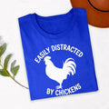 Easily Distracted By Chickens T Shirt makes a thoughtful gift for chicken mums, chicken dads, poultry farmers, backyard chicken owners, homesteaders, rural families, animal lovers, farmers, friends, brothers, sisters, husbands, wives, and anyone passionate about raising chickens. Designed by Teezora Prints, this premium graphic shirt is perfect for birthdays, Christmas, Mother's Day, Father's Day, farm celebrations, retirement gifts, and memorable surprises for poultry enthusiasts.