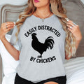 Easily Distracted By Chickens T Shirt is designed for people who love collecting fresh eggs, caring for backyard chickens, living the homestead lifestyle, and enjoying peaceful country mornings. Featuring a bold rooster silhouette with clean typography, this premium graphic tee from Teezora Prints perfectly reflects a passion for poultry, farming, and rural life. Ideal for everyday casual wear, farm work, weekend markets, countryside holidays, travel, and anyone proud to show their love for chickens.