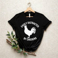 Easily Distracted By Chickens T Shirt created for chicken lovers, backyard chicken keepers, poultry farmers, homesteaders, smallholders, country lifestyle enthusiasts, farm animal lovers, rural families, and anyone who can't resist stopping to admire chickens. Featuring a bold chicken silhouette with modern typography, this premium graphic tee from Teezora Prints celebrates farm life while offering exceptional comfort, premium print quality, stylish everyday fashion, and a fun personality for poultry enthus