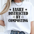 Perfect for gardeners, compost enthusiasts, plant lovers and anyone passionate about sustainable living, this Easily Distracted by Composting shirt adds humour to every gardening day. Whether you're working in the garden, managing an allotment or creating nutrient-rich compost, this premium graphic tee combines comfort with personality. Every shirt is professionally printed in the UK by TeezoraPrints for exceptional quality and long-lasting wear.