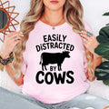 Searching for the perfect gift for a cow lover? This Easily Distracted by Cows shirt is a thoughtful present for farmers, ranchers, dairy workers, countryside enthusiasts and anyone who smiles whenever they see cattle. Every premium t-shirt is printed in the UK by TeezoraPrints, making it a memorable gift for birthdays, holidays and special occasions.