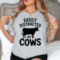 Celebrate your passion for farming and country living with this Easily Distracted by Cows shirt. Whether feeding livestock, exploring the countryside, visiting a dairy farm or spending weekends outdoors, this premium t-shirt keeps you comfortable while showing your love for cattle. Proudly printed in the UK by TeezoraPrints for reliable quality and timeless style.