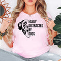 Show everyone you're a proud dog lover with this Easily Distracted by Dogs graphic t-shirt featuring a cute dog illustration and eye-catching typography. The premium unisex fit offers all-day comfort while the fun design makes it perfect for everyday outfits, dog walks and casual weekends. Every shirt is made to order and professionally printed in the UK by TeezoraPrints.