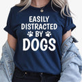Let everyone know where your attention goes with this Easily Distracted by Dogs graphic t-shirt. The bold slogan and cute paw print design create the perfect combination of humour and style for every dog lover. Soft premium cotton and professional printing ensure lasting comfort, with every shirt proudly printed in the UK by TeezoraPrints.