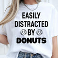 Easily Distracted by Donuts shirt, funny donut lover t shirt, bakery lover tee, foodie shirt, dessert lover apparel, coffee lover clothing, sweet tooth gift, donut graphic tee, novelty food shirt and humorous casual fashion. Every premium t-shirt is proudly printed in the UK by TeezoraPrints for long-lasting comfort and quality.